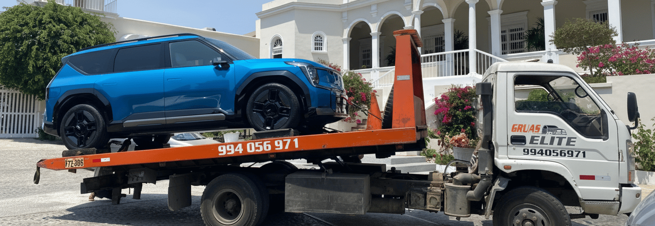 Camioneta azul asegurada con correas sobre la plataforma de una grúa de Grúas Elite